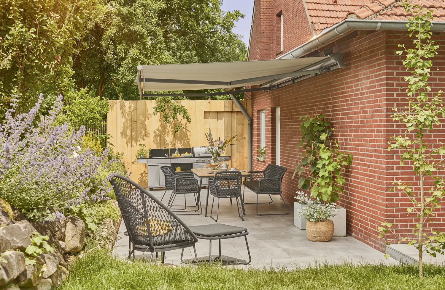 Moderne Terrasse mit Markise, Grill und stilvollen Gartenmöbeln